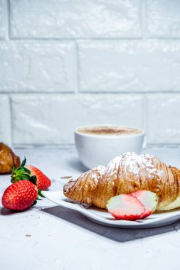 Kruvasan ile Avrupalı kahvaltı. Kahve ve taze çilek.