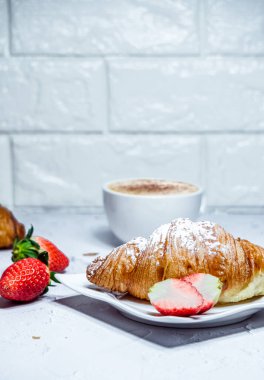 Kruvasan ile Avrupalı kahvaltı. Kahve ve taze çilek.