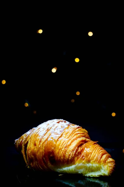 Croissant Azúcar Glaseado Tiene Fondo Negro Bokeh — Foto de Stock