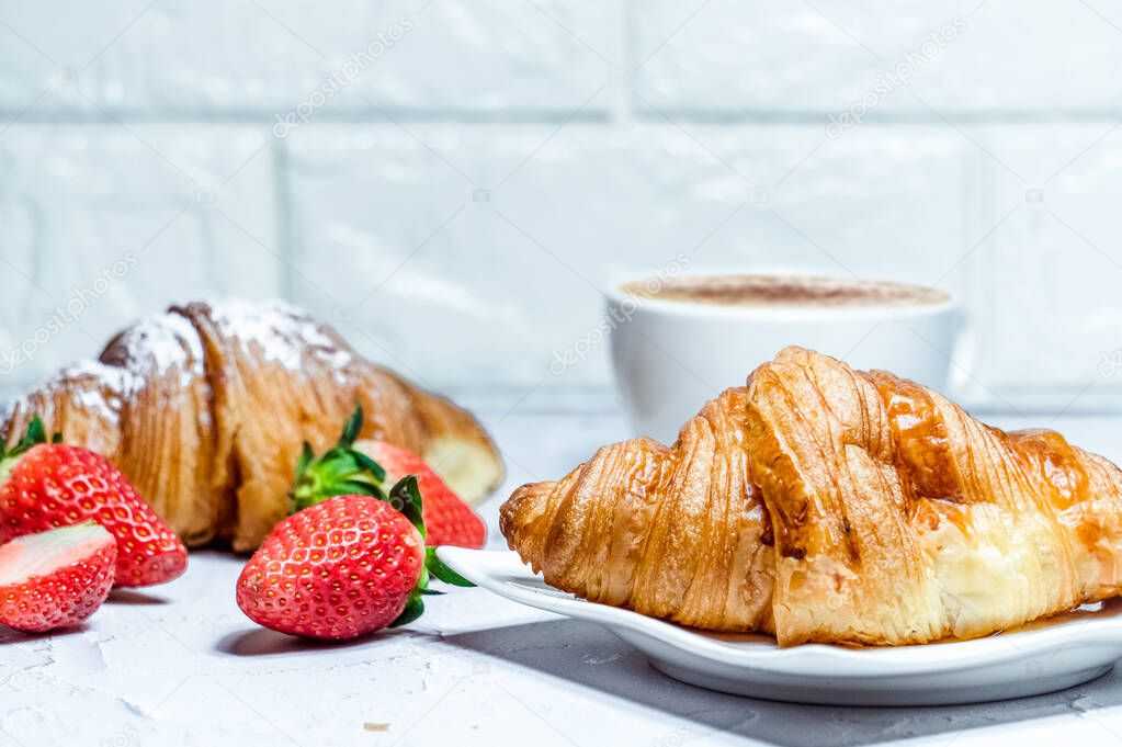 Continental breakfast with croissants. Coffee and fresh strawberries