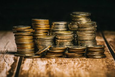 Yüksek ve düşük rakımlı madeni paralar eski ahşap masa üstü ve siyah arkaplan üzerine yerleştirilmiştir..