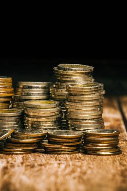 Yüksek ve düşük rakımlı madeni paralar eski ahşap masa üstü ve siyah arkaplan üzerine yerleştirilmiştir..