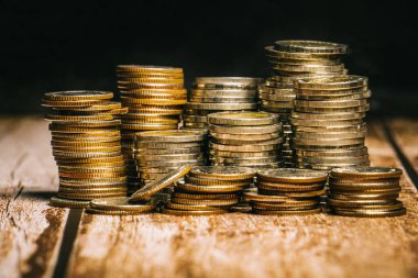 Yüksek ve düşük rakımlı madeni paralar eski ahşap masa üstü ve siyah arkaplan üzerine yerleştirilmiştir..