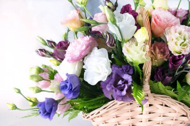 Samandan bir sepetin içinde çok renkli güzel bir çiçek buketi. Büyük bir bukette beyaz, pembe, mor, sarı taze güller. Çiçekçilik konsepti. Yakın plan.