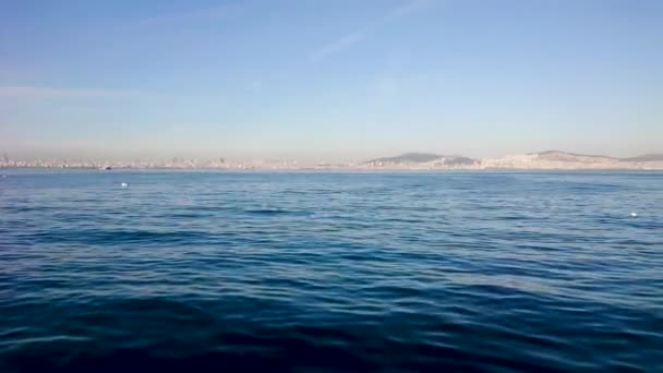 素晴らしい景色を海からイスタンブールへ 澄んだ青空が地平線の街に後退します 水の上には大きな丘 小さなヨットが見えます カメラは横に動く — ストック動画