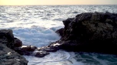 Incredible drone view of the Bosphorus, captured from the Arnavutkoy area of Istanbul. Lots of houses and trees on the hillsides. A high hill is covered with haze, which obscures part of the sky. A cargo ship is sailing along the strait. 