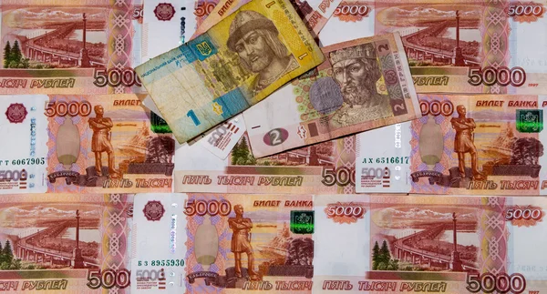 Много российских рублей и две украинские гривны — стоковое фото