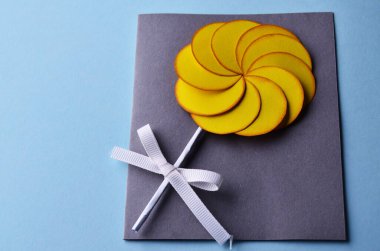 Adım adım fotoğraf çekerek bir çiçekle nasıl kartpostal atılacağını öğretiyorum. Yedinci adım. Çiçek ve yapıştırıcının altına bir fiyonk koyun. Kartpostal hazır.. 