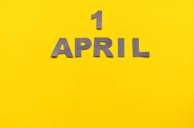 Yazı 1 Nisan 'da, sarı bir arkaplanda, kopyalama alanı olan gri harflerden yapılmış.