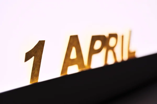 Напис 1 квітня жовтих літер на фоні білої світлодіодної лампи — стокове фото
