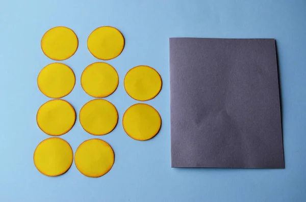 Stap-voor-stap foto-instructie hoe je een ansichtkaart maakt met een bloem. Stap 3. Kant-en-klare gele cirkels en onderstel voor een ansichtkaart van grijs papier Stockafbeelding