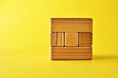 Ahşap yapboz küpü parçalara bölünmüş. Kopya alanı olan sarı bir arka plan değil. Mantıklı bulmaca görevleri