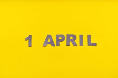 Yazı 1 Nisan 'da, sarı bir arkaplanda, kopyalama alanı olan gri harflerden yapılmış.