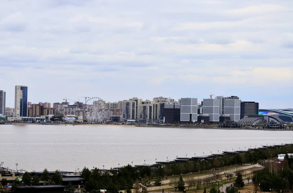 Panorama tem vista para a cidade com novos edifícios modernos do outro lado do rio em um dia nublado. Rússia Kazan 24.04.2021 — Fotografia de Stock