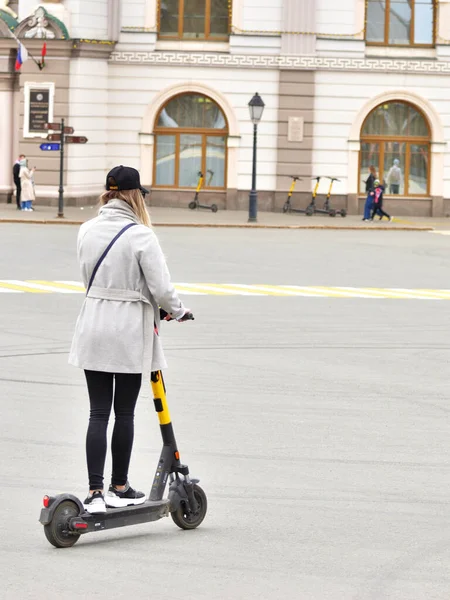 Dívka turista na elektrickém skútru vyjíždí na ulici města. Rusko Kazan 24.04.2021 — Stock fotografie