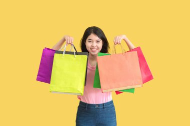 Yazın Asyalı bir kadın. Gülümsüyor ve alışveriş torbaları var. Yaz Sürprizi Konsepti.