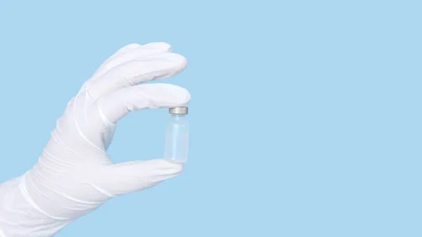 Vaccine bottle in hand wearing white rubber gloves isolated on blue background.