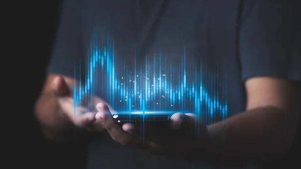 İşadamı ya da tüccarın eli akıllı telefonlarda büyüyen sanal bir hisse senedi gösteriyor..