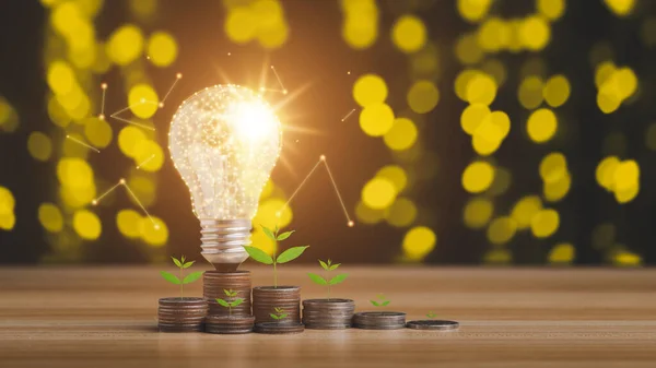 Coins grow in a stack with a light bulb background bokeh yellow. Saving energy and money idea for saving money income concept.
