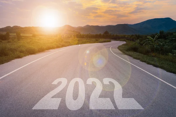 New year 2022 or start straight concept. 2022 written on the road in the road at sunset.