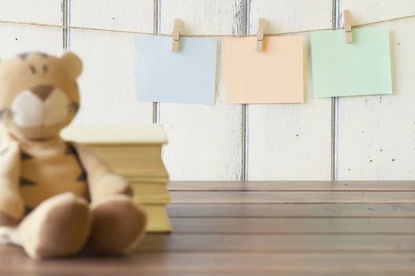 Tres hojas de papel colgando de ganchos para tender ropa. Fondo de azul