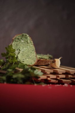 Sarımsaklı, tereyağlı ve baharatlı Rustik sandviç. Kırmızı yüzeyde gölgeli yiyecek fotoğrafçılığı.