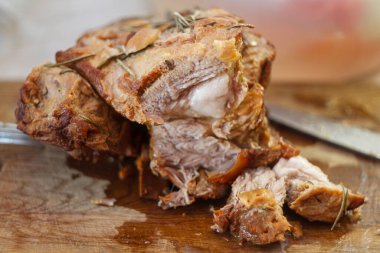 Yağlı ahşap bir kesme tahtasının üzerinde kızarmış et parçaları. Ev yapımı köy yemeği kaldı..