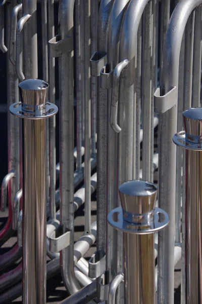 Chrome posts and metal barriers placed on a street side for an upcoming event