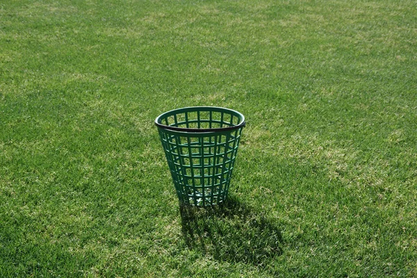 在高尔夫球场上放空的绿色高尔夫球桶 — 图库照片