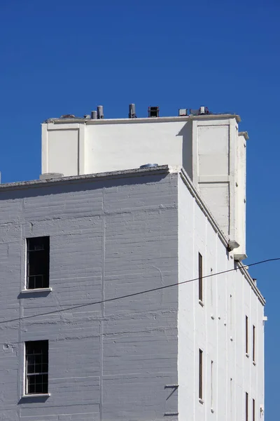 Vista Baixo Ângulo Partes Antigo Armazém Branco Sob Céu Azul — Fotografia de Stock