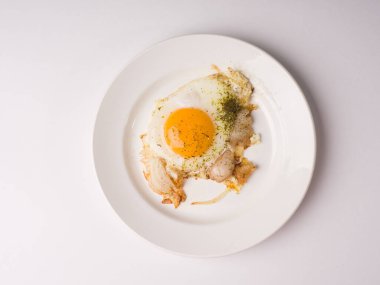 Beyaz yuvarlak tabakta sahanda yumurta. Beyaz arkaplanda stüdyo fotoğrafı