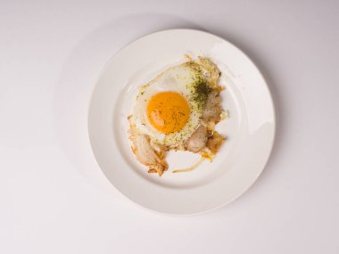 Beyaz yuvarlak tabakta sahanda yumurta. Beyaz arkaplanda stüdyo fotoğrafı