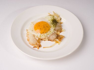 Beyaz yuvarlak tabakta sahanda yumurta. Beyaz arkaplanda stüdyo fotoğrafı