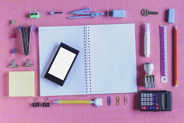 Hoge hoek weergave van kleurrijke School leveringen georganiseerd door Type rond nota boek Open voor lege pagina gerangschikt op roze stof — Stockfoto