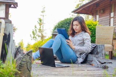 Tablet ile dizüstü bilgisayar kullanarak bir genç kadın serbest meslek portresi 
