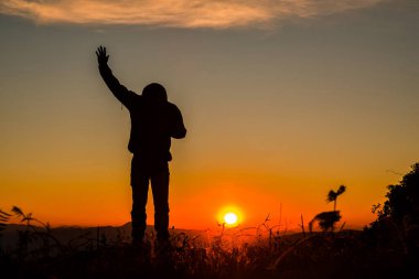 Din, ibadet, dua ve övgü kavramında elleri havada bir adamın silueti.