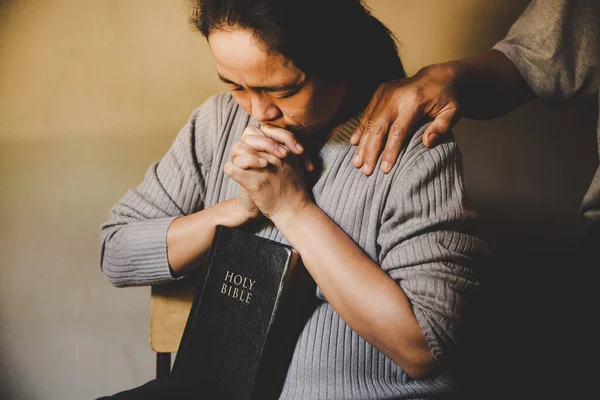 Couple reading bible and pray together at home. Two people are praying together. close hands
