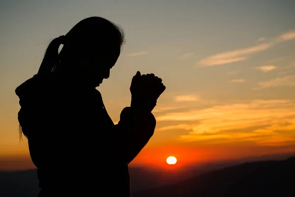 Silhouette of christian woman hand praying, spirituality and religion, woman praying to god. Christianity concept.
