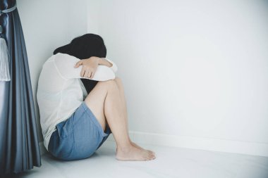 Yalnız ve bunalımda olan genç bir kadın. Depresyondaki kadın yerde oturuyor, taciz ediyor ve insan konsepti yapıyor.