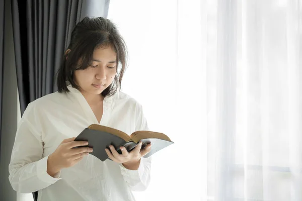 Christian teenage girl reading the Holy Bible, Reading a book. Christian life crisis prayer to god.