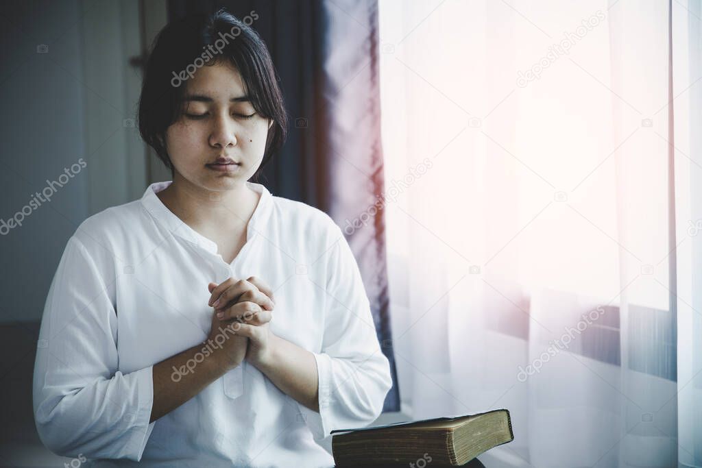 Christian life crisis prayer to god. Young woman pray for god blessing to wishing have a better life. Girl hands praying to god with the bible. begging for forgiveness and believe in goodness.