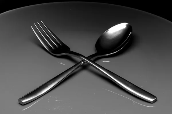 Forchetta e cucchiaio in argento come utensili su piatto — Foto Stock