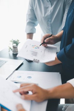 Modern ofisteki tablolar ve grafiklerle mali raporları gözden geçiren iş ekibi çalışması, analiz, planlama stratejisi, büyüme ve belge ve teknoloji ile kurumsal başarıyı tartışan meslektaşlar.