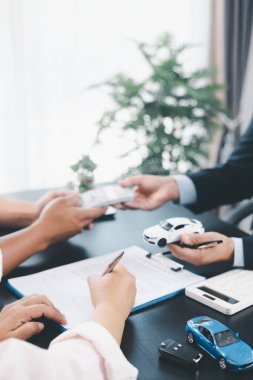 Araç modeli, otomobil finansmanı, kiralama, sigorta ya da satın alma anlaşması, iş görüşmesi ve finansal planlama gibi konuları gösteren bir dağıtıcı ile araba kredisi sözleşmesi imzalayan müşteri. otomatik finans.