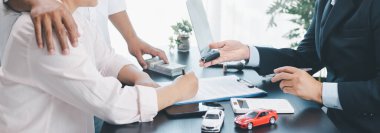 Kontrat imzalanırken araba satıcısının müşteriye anahtar ve araç modeli, otomobil kredisi, finans, kiralama, sigorta, satın alma anlaşması ve iş başarısı konsepti sunduğu panorama manzarası. otomatik kredi.