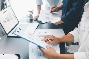 Modern ofisteki tablolar ve grafiklerle mali raporları gözden geçiren iş ekibi çalışması, analiz, planlama stratejisi, büyüme ve belge ve teknoloji ile kurumsal başarıyı tartışan meslektaşlar.