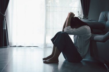 Evdeki kanepede oturan umutsuz, yorgun kız. Genç kadın oturma odasında oturuyor, üzgün ve depresif hissediyor. Psikolojik bir sorun. Depresyon ve yalnızlık kavramı.