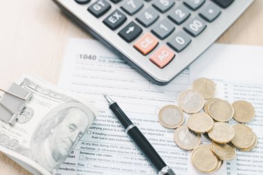 Vergi sezonu ve mali muhasebe kavramı. Gelir vergisi formlarına konulan yığınla fatura, ödemeyi, iş finansmanını, bütçe yönetimini ve kişisel gelir raporunu sembolize ediyor.