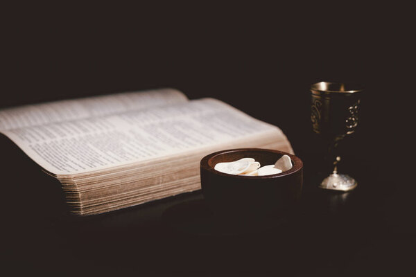 Священный хлеб и чаша вина, возложенные на Священную Библию, символизирующие Вечерю Господню, Евхаристию, жертву Иисуса Христа, христианское поклонение и память о вере.