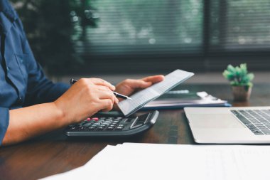 Ofis işkadını eli hesap makinesini çalıştırıyor. Finansal verileri analiz ediyor, masaları sayıyor. muhasebe, iş bütçesi planlaması için mali analiz, hesaplama desteği, finans yönetimi.